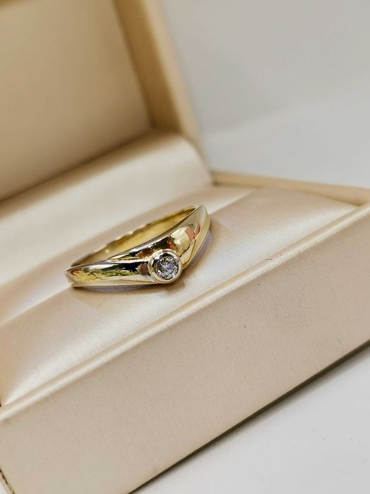 Pierścionek z centralnym brylantem w złocie.