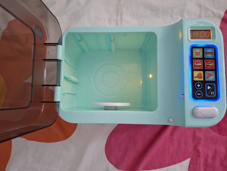 Microondas de brinquedo e loiça de brincar.