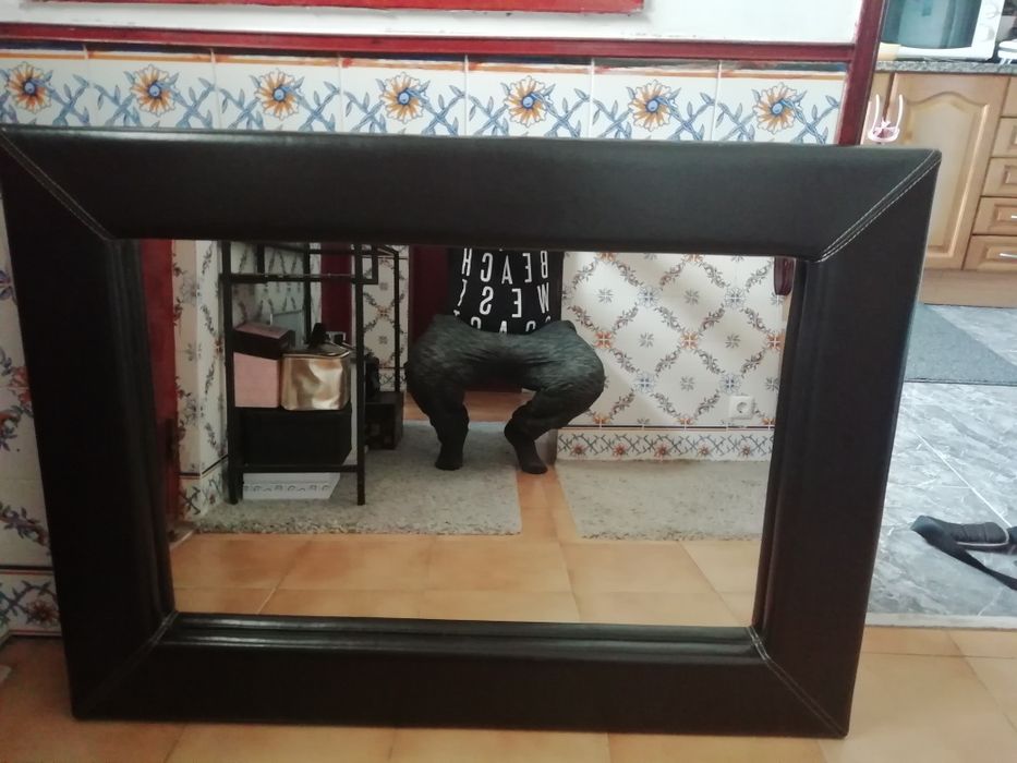 Espelho com moldura em pele.