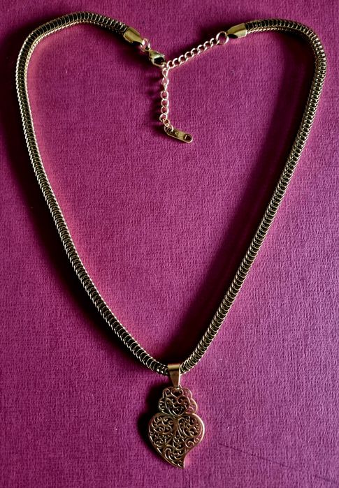 Colar dourado, em aço, malha grossa e um coração de Viana em filigrana