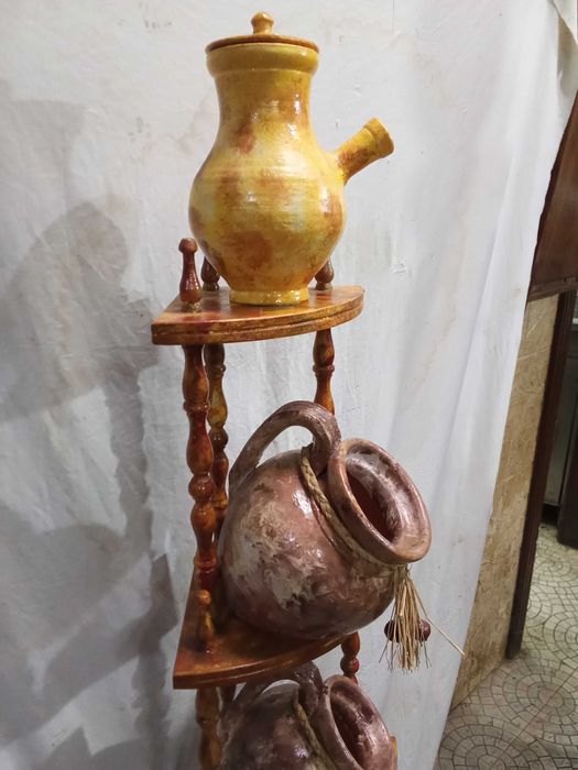 Estante de canto em madeira pintada em tons castanhos