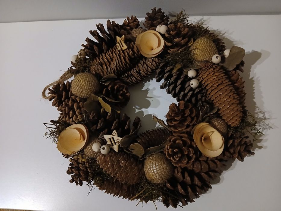Coroa com pinhas e decorações de madeira