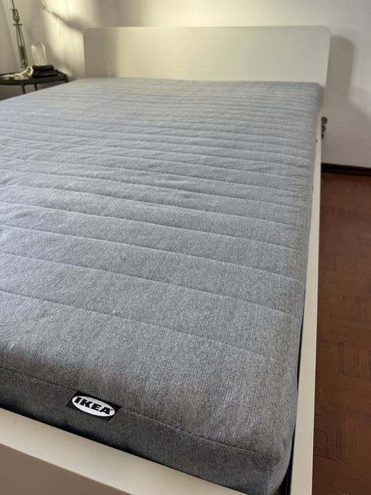 Estrutura de cama branca e colchão de mola IKEA com 140x200.