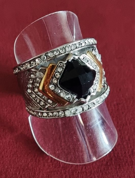 Anel prateado, em aço, com zirconias e uma pedra preta lapidada. T19