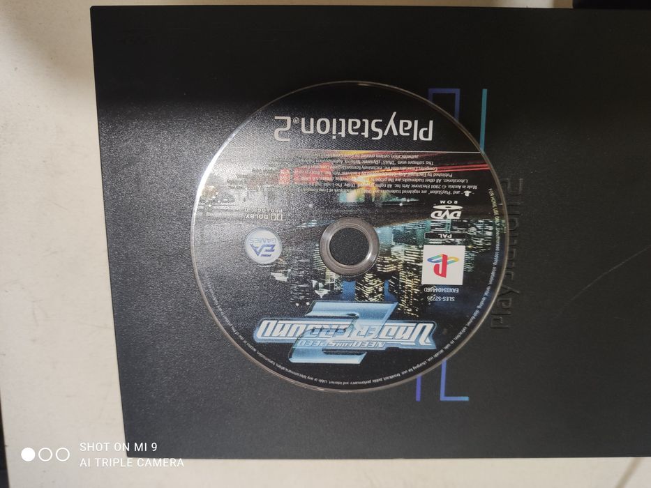 PS2 com comando e um jogo