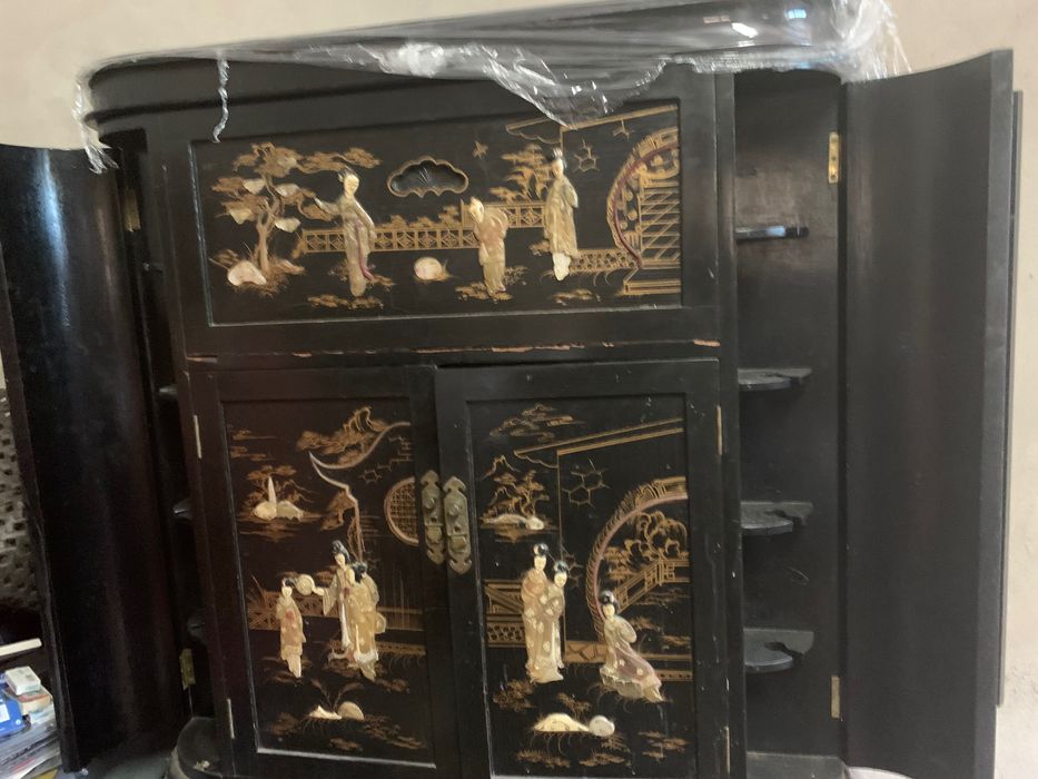 Um móvel bar preto com desenhos doutado