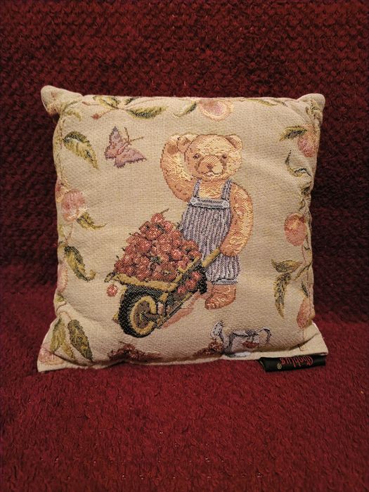 Boneca de porcelana com almofada de ursinho  dela