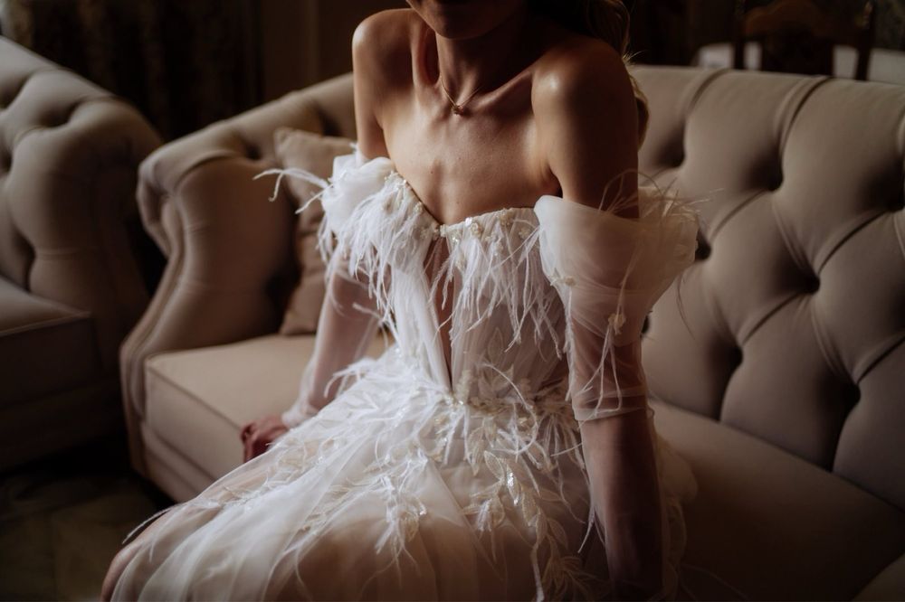 Suknia ślubna z piórkami, gorsetowa, z opadającymi rękawkami