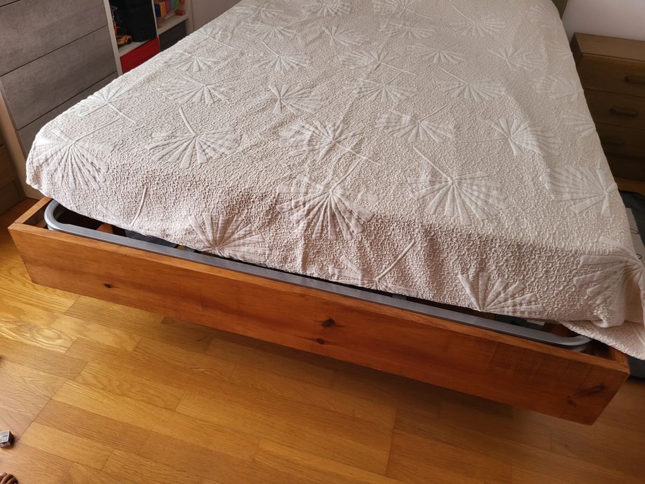 Cama de madeira com cabeceira forrada