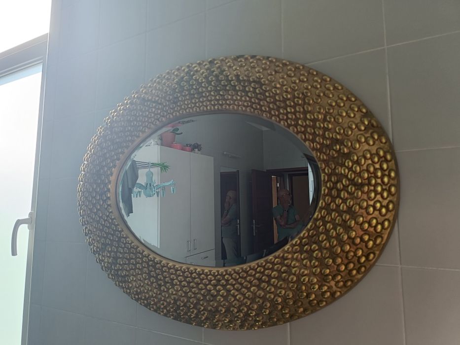 Espelho oval com moldura dourada