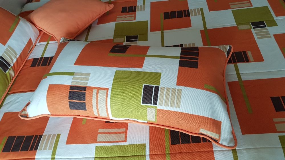 Conjunto colcha e almofadas em tons laranja, creme, castanho e verde