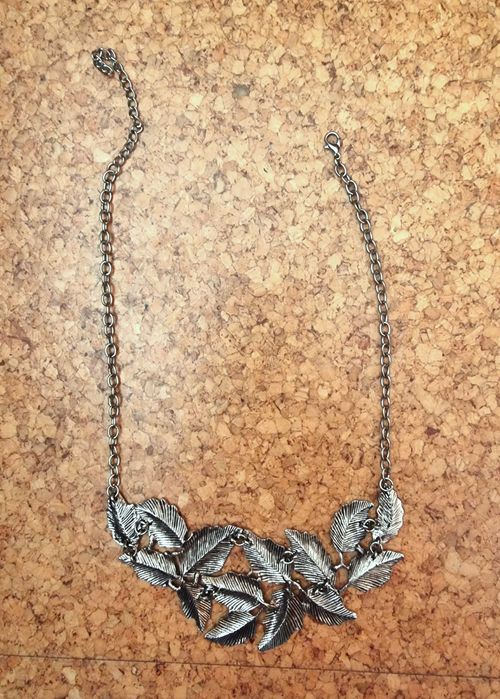 Colar prateado com detalhes de folhas