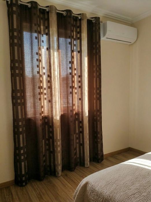 Um cortinado elegante com argolas em excelente estado