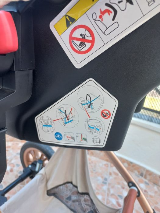 Carrinho de bebé com mmarcas de uso no puxador.