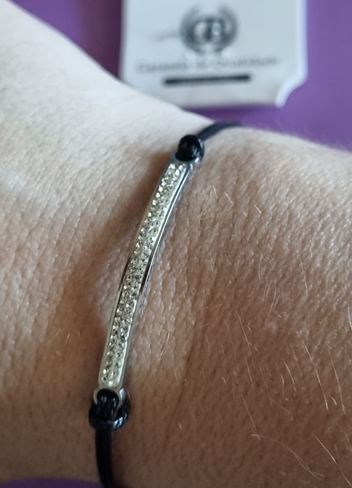 Pulseira preta e prateada, em aço. Chapinha com 2 fiadas de zirconias. Ajustável
