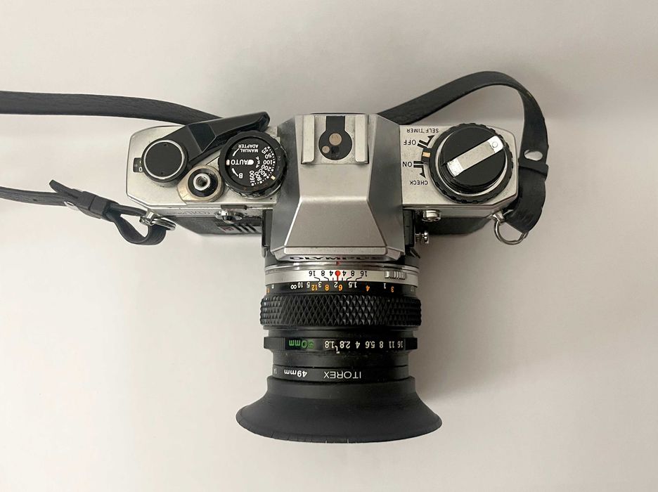 Olympus OM-10 + Lente Zuiko 50mm f/1.8 + Parasol – Excelente Estado