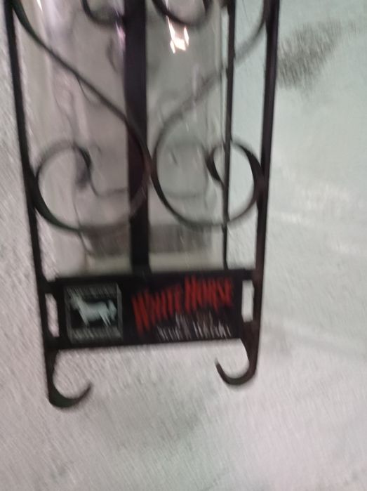 Suporte em ferro e garrafa de whisky.