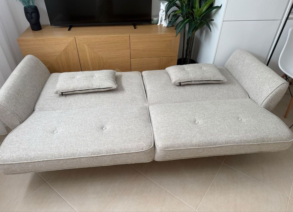 Sofá cama bege em tecido com 2 almofadas