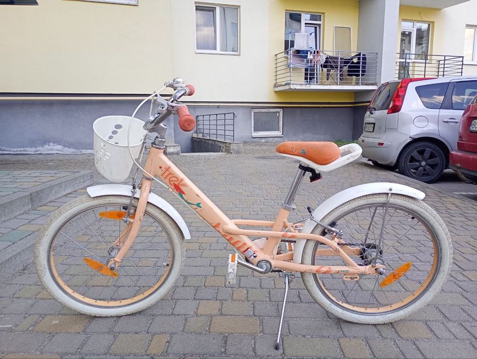 Це дитячий велосипед Trek Mystic 20 персикового кольору з білою корзиною