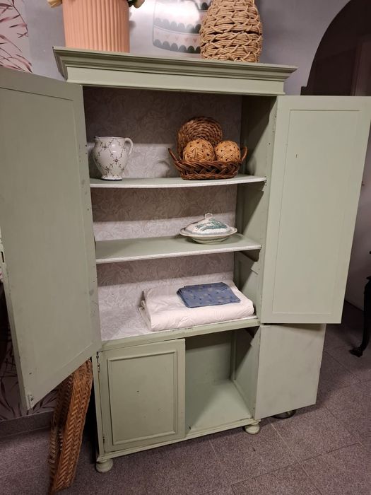 Armário vintage em madeira pintado de verde suave.