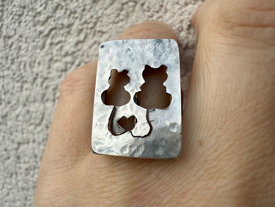 pierścionek z zakochanymi kotami, których ogony tworzą serce.
Sr 925