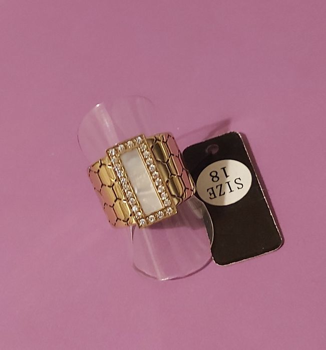 Anel dourado, em aço trabalhado, com uma madrepérola retangular rodeada de zirconias. T18
