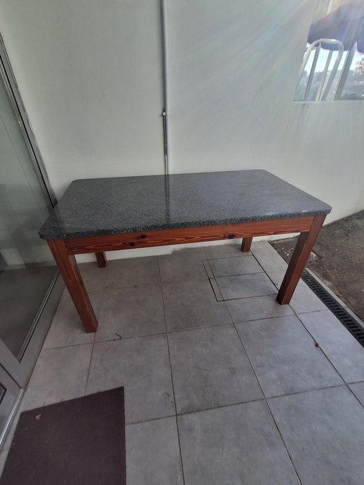 Mesa de cozinha com granito e base em madeira mogno.