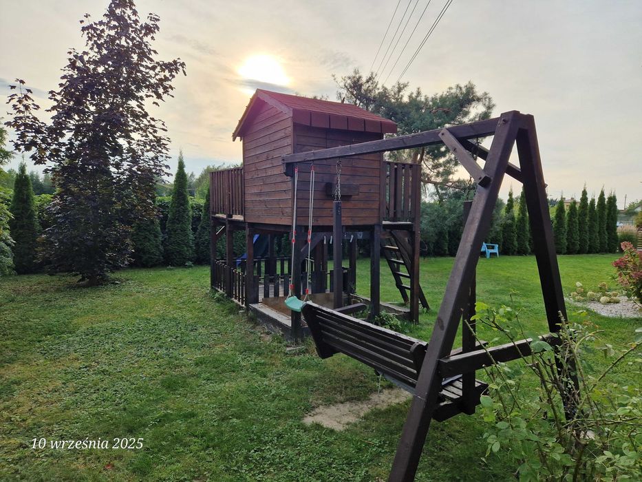 Duży drewniany domek dla dzieci z huśtawką