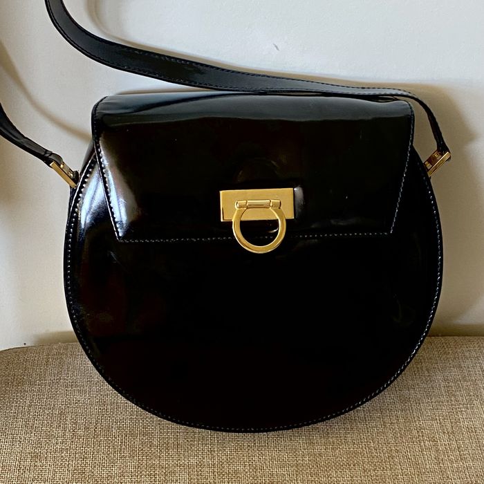 Bolsa em pele, Aries, com acabamento em verniz e fecho magnético.