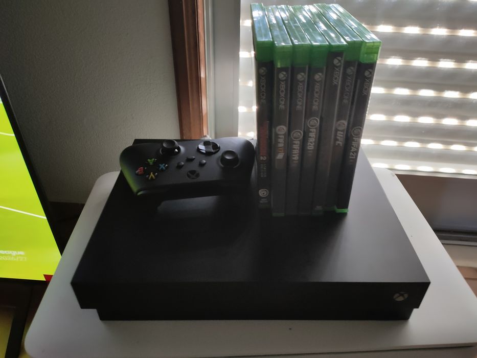 Xbox One X com jogos e headphone