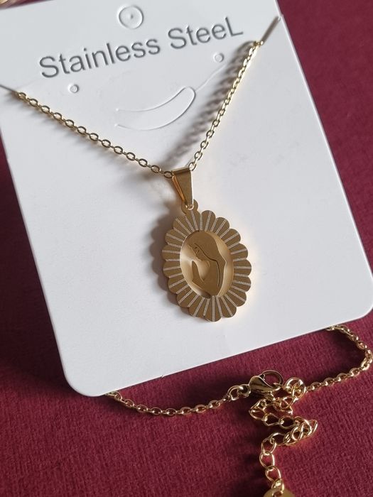 Colar prateado/dourado, em aço, com pingente da Nossa Senhora. Tem extensor