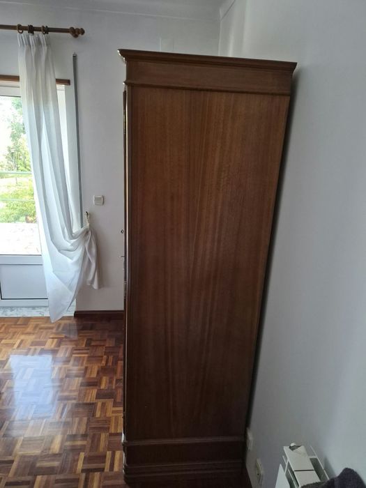 Quarto com cama (2m × 1,80m), 2 mesas de cabeceira e roupeiro.