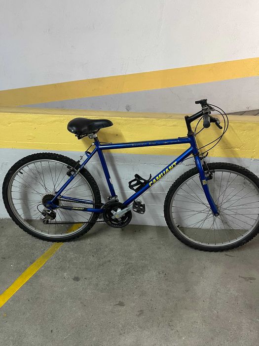 Bicicleta de montanha com cadeado e capacete, estado usado