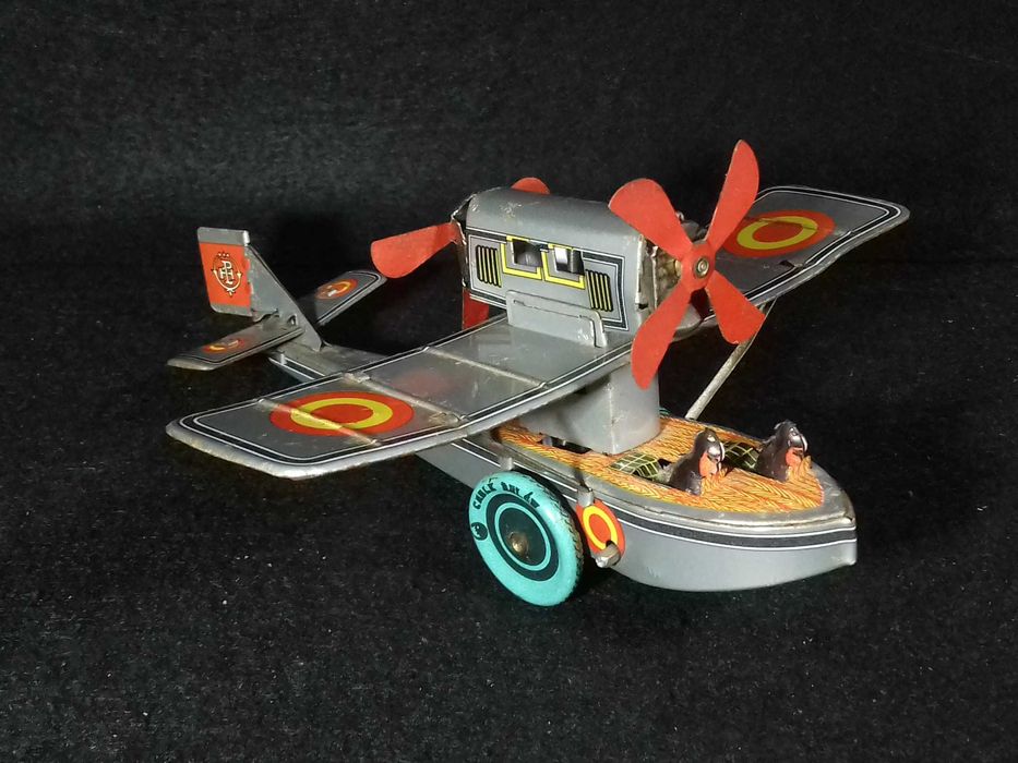 Miniatura de avião antigo em metal, com sistema mecânico de corda;