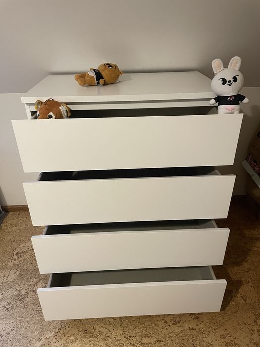 Biała komoda z głębokimi szufladami.