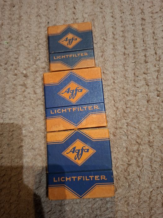 Pudełko zawiera filtr fotograficzny Agfa Lichtfilter, element wyposaże