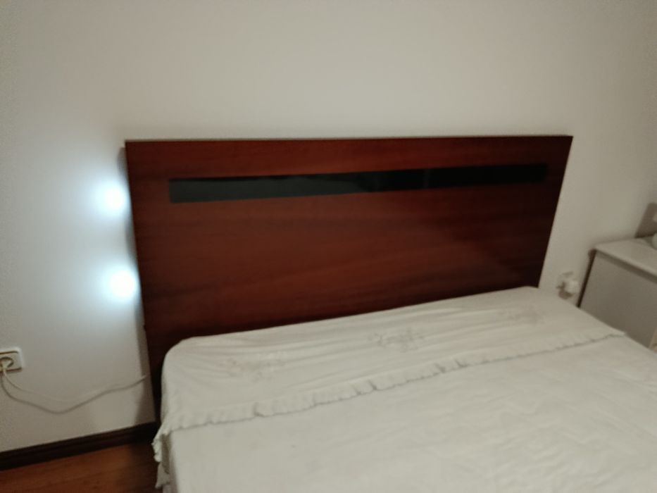Cama grande de casal, com arrumação.