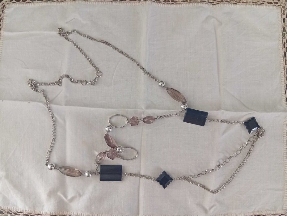 Colar em metal prateado, com aplicações pretas e cinza rosado