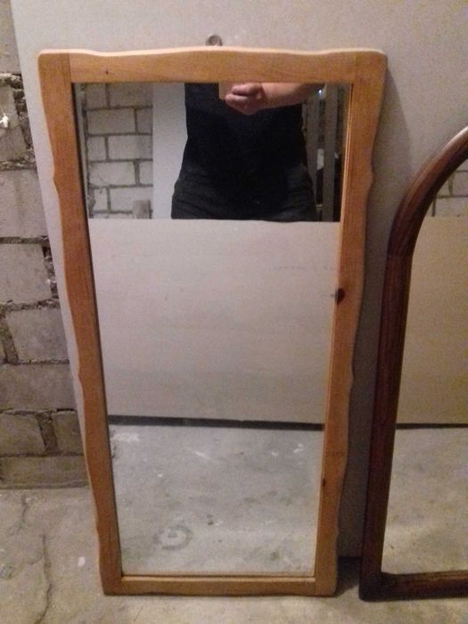 Lustra ścienne w drewnianych ramach.