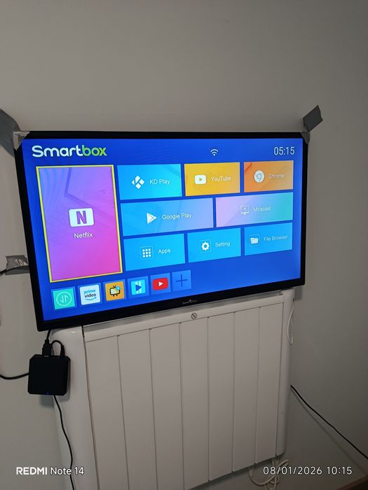 Um sofá cama, três Tvs e um refrigerador.