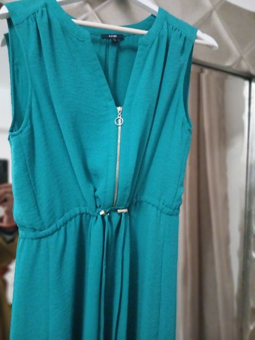 Vestido azul esverdeado, veste pequeno, ligeiramante abaixo do joelho,