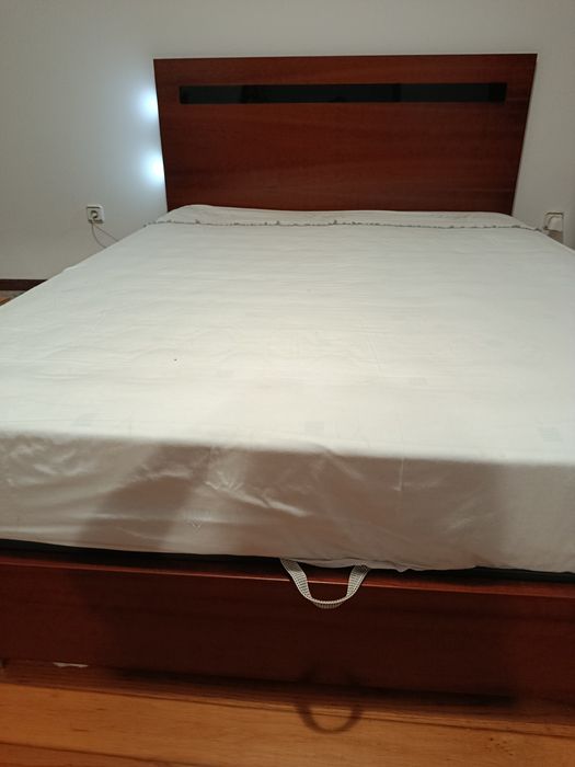 Cama grande de casal, com arrumação.
