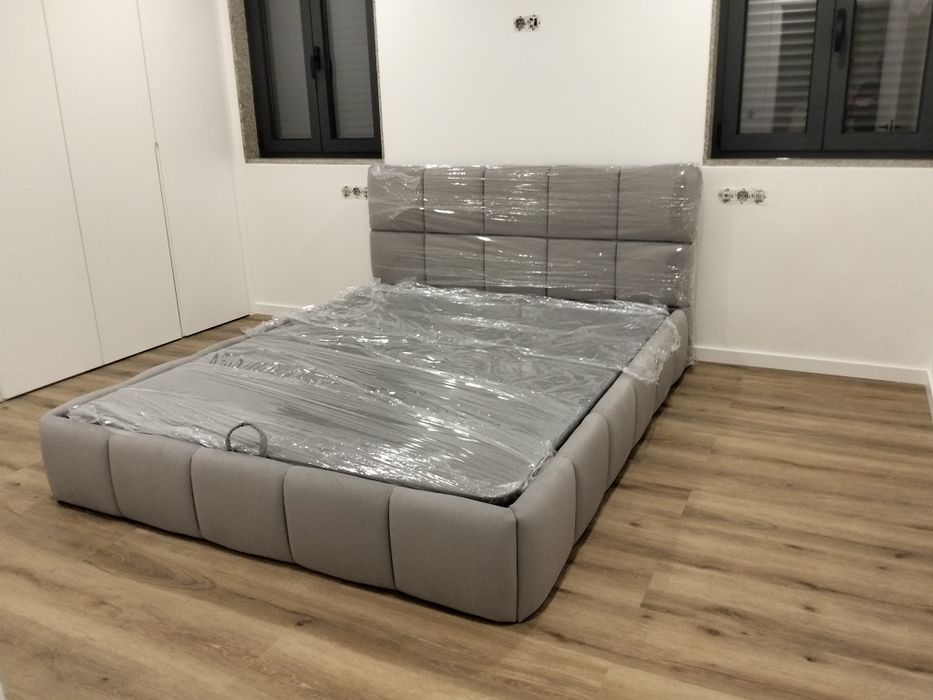 Cama em tecido nova com estrado elevatória incluída.