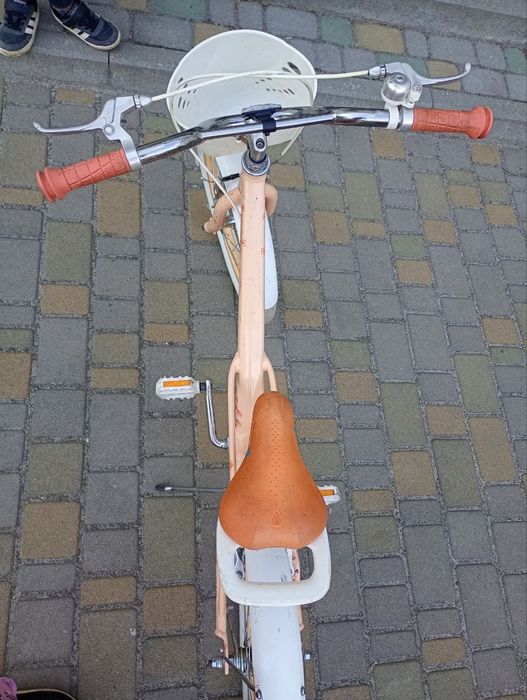 Це дитячий велосипед Trek Mystic 20 персикового кольору з білою корзиною