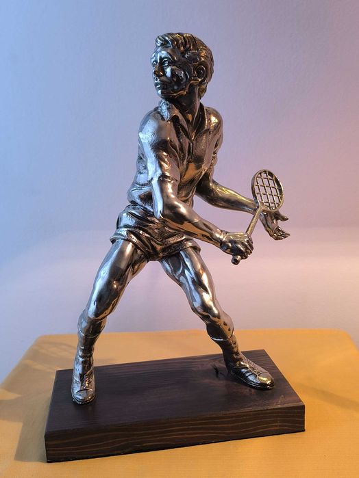 Escultura em metal prateado de jogador de ténis, com base em madeira