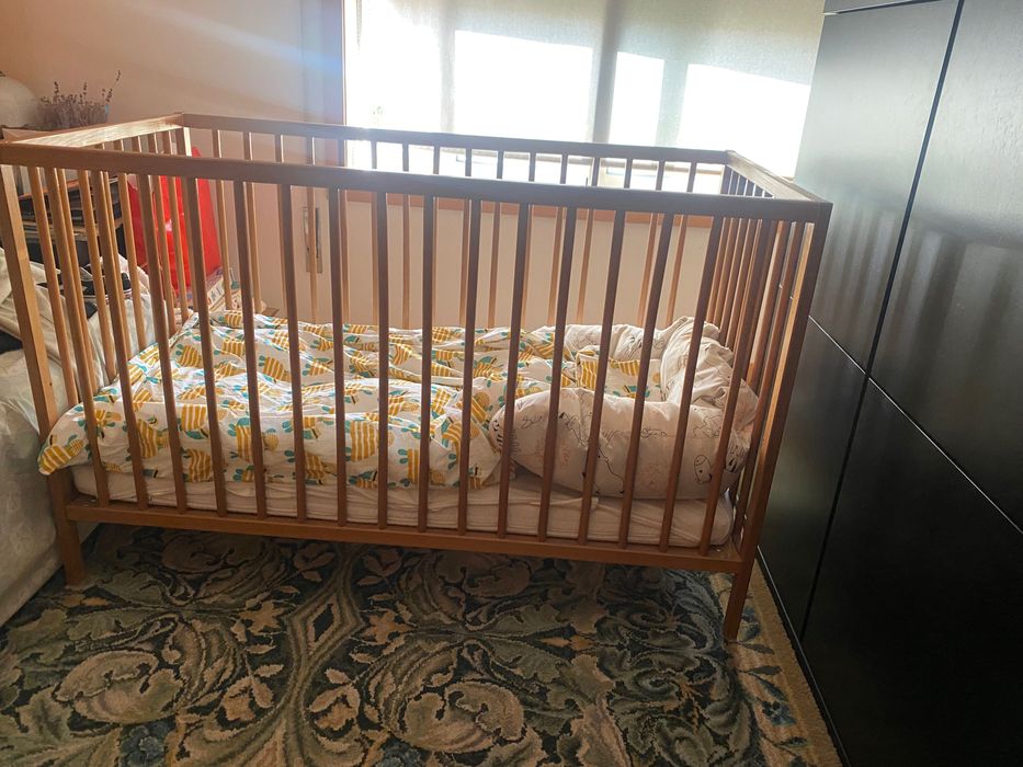 Cama de grades em madeira natural com colchão e resguardo