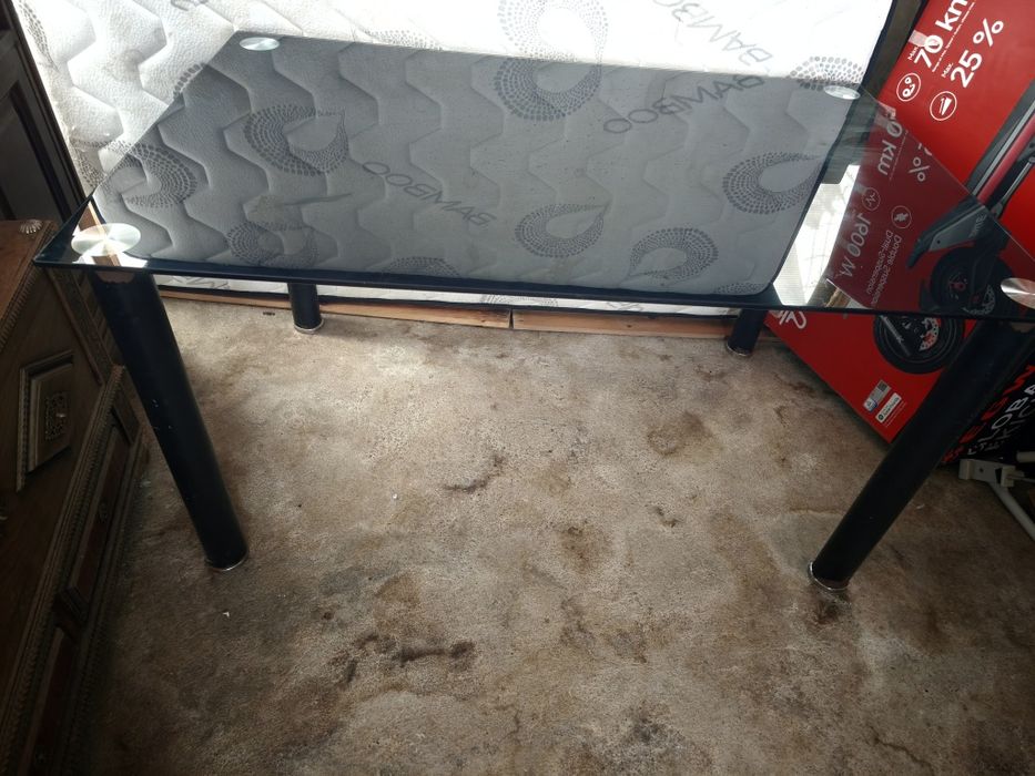 Mesa com o tampo em vidro 140 por 90 e os pés tem um pouco de tinta descascada como se vê nas fotos