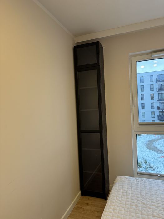 Wysoki regał z półkami na drzwiczki