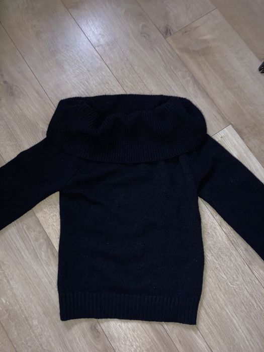 Czarny sweter bez ramion.