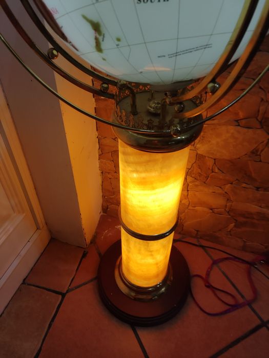 Globo com o mapa do mundo com estrutura em pedra e com base de madeira